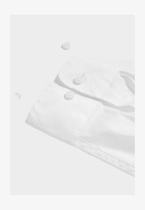 Witte langwerpige shirtmanchet met twee knoopsluitingen, met een soepele textuur en strakke gestikte details. Knopen zijn rond en van plastic.