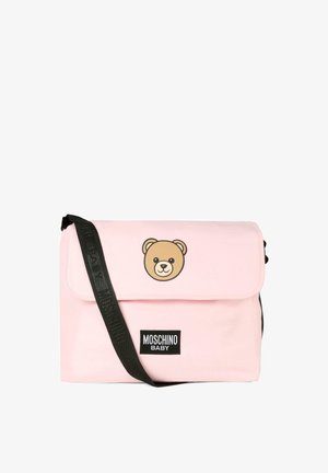 Borsa a tracolla rosa chiaro realizzata in tessuto morbido, presenta una grafica di un orso bruno sul pattino, una cinghia nera regolabile e un'etichetta nera con il marchio.