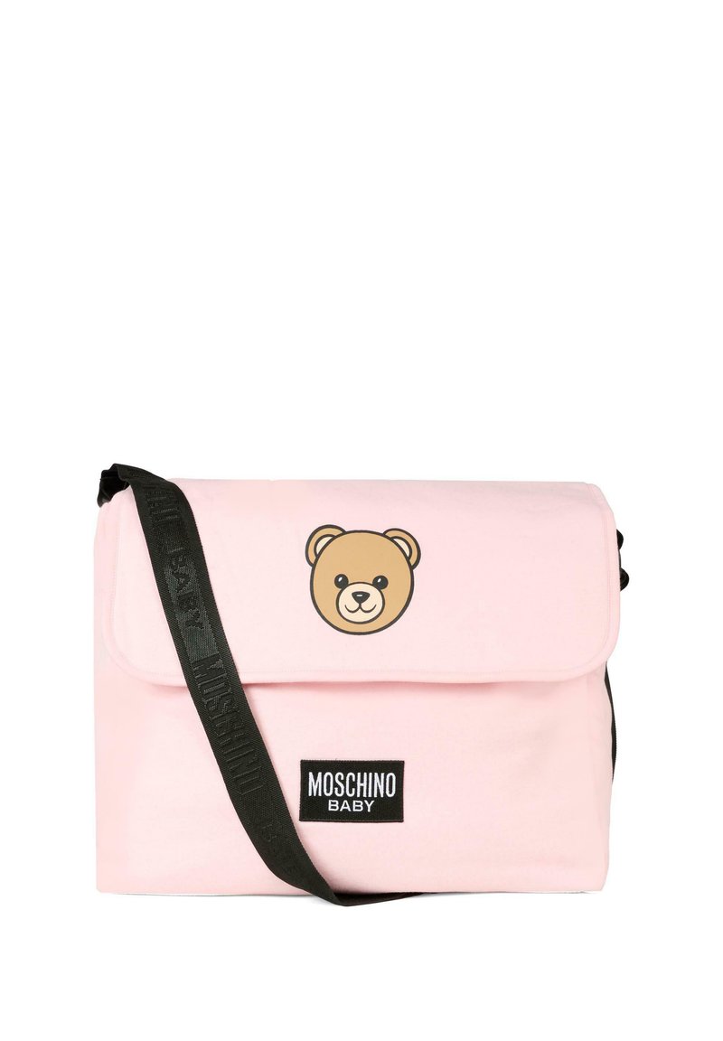 Borsa a tracolla rosa chiaro realizzata in tessuto morbido, presenta una grafica di un orso bruno sul pattino, una cinghia nera regolabile e un'etichetta nera con il marchio.