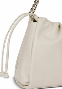 Bolso de cuero color crema con una textura suave, cierre de cordón y correa de cadena metálica. Presenta un diseño minimalista y curvas sutiles.