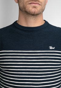 Pull en maille bleu marine avec un col rond, orné de rayures blanches horizontales et d'un petit logo sur la partie supérieure gauche de la poitrine.