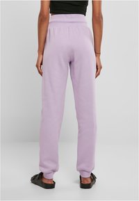 Pantalon de survêtement violet avec une taille élastique et des poignets élastiques, fabriqué en tissu doux en mélange de coton. Présente une coupe décontractée et des détails de couture minimalistes.