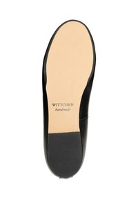 Suela de zapato de cuero negro con un acabado suave, presenta una plantilla de color marrón claro y una parte inferior texturada para mayor agarre. "Wittchen hecho a mano" grabado.