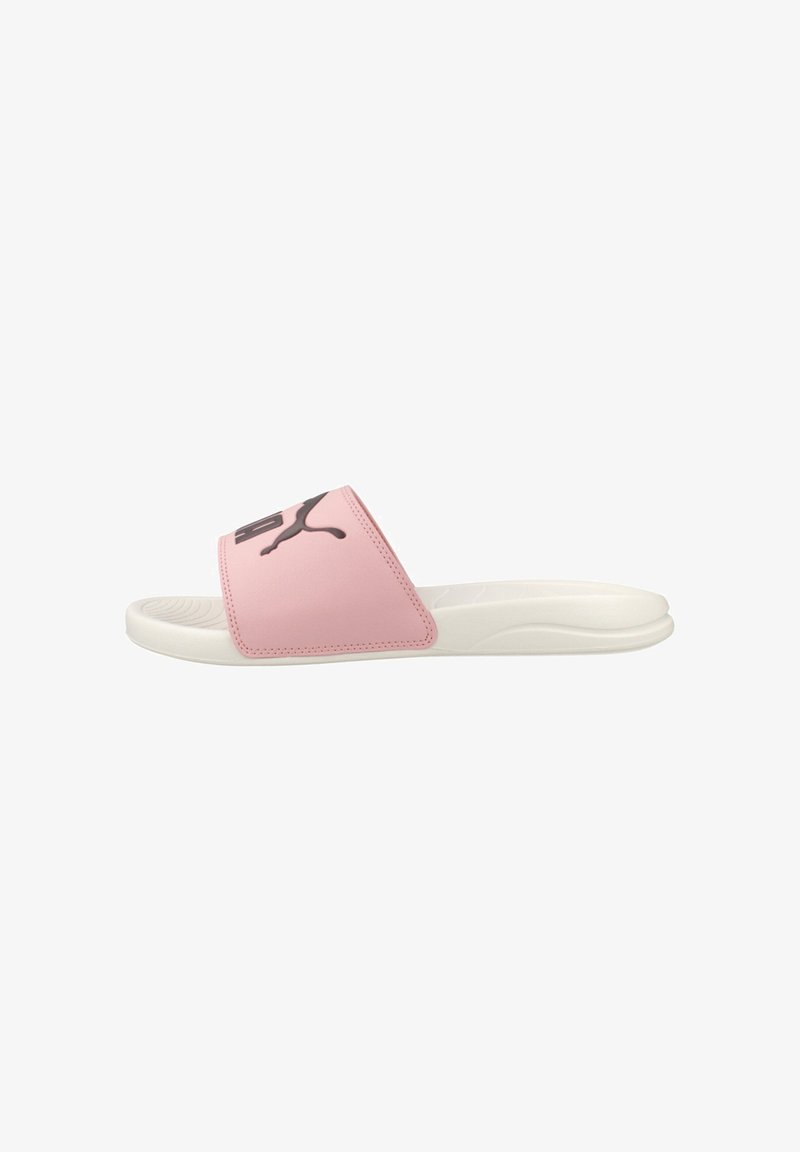 Sandale blanche à semelle glissante avec bride rose présentant un logo Puma noir, une semelle intérieure texturée et une semelle profilée pour un usage décontracté.