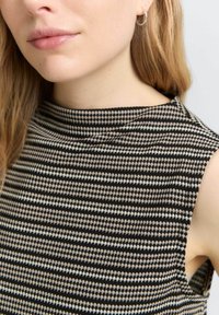 Mouwloze top met een gestructureerde halslijn, gemaakt van textiel met een gemêleerd patroon in zwart en beige, met een geometrisch ontwerp.