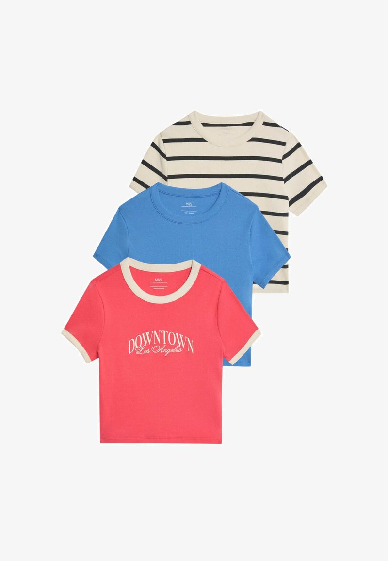 Tres camisetas apiladas: una azul sólida, una coral con el texto "DOWNTOWN Los Ángeles" y una crema con rayas negras. Todas tienen escotes en contraste.