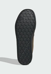 Musta kuminen pohja, jossa on teksturoitu, pisteellinen kuvio. Ruskea nahkainen päällinen siirtyy pohjaan, jossa on "STEALTH" -logo. Liukumaton muotoilu.