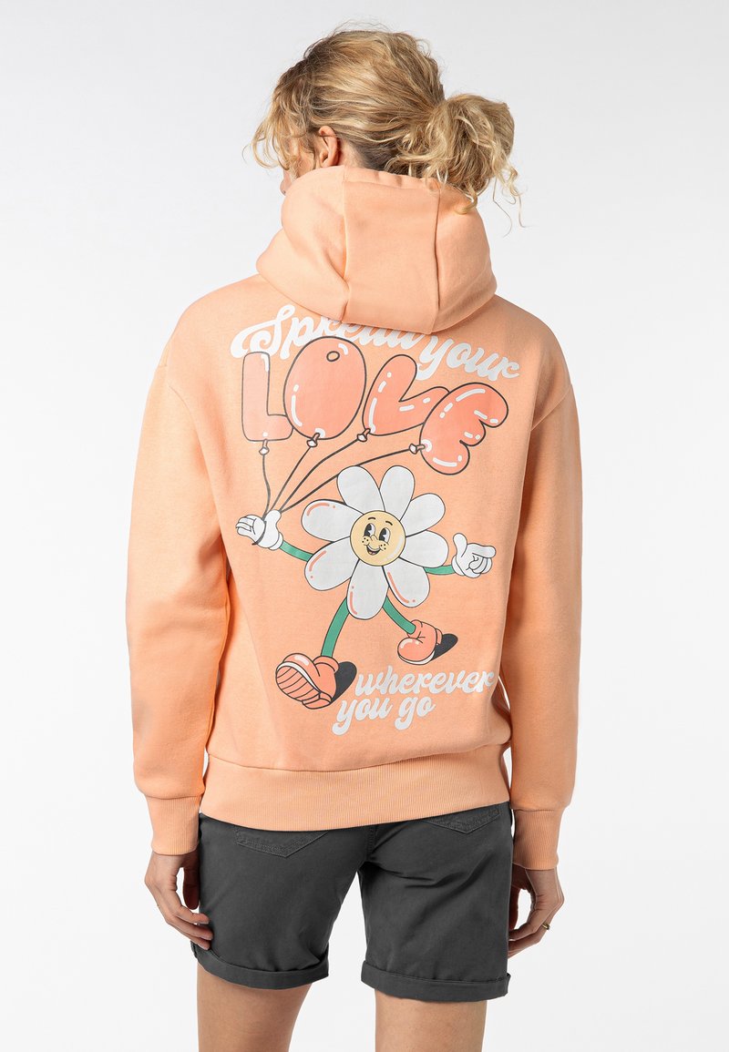 Perzikkleuren hoodie met een grafisch ontwerp van een cartoonbloem en ballonnen op de achterkant, geribde boorden en een trekkoordcapuchon.