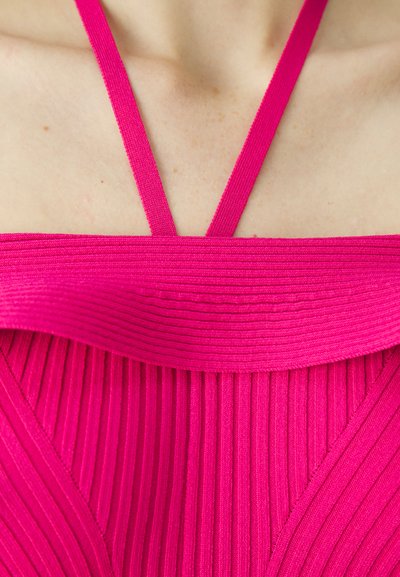 Robe fuchsia avec texture côtelée, dotée de fines bretelles et d'un décolleté arrondi. Le tissu lisse met en valeur le design structuré.