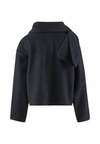 Giacca in pile blu navy con colletto alto, spalle cadute e un distintivo drappeggio sul retro. Tessuto morbido e vestibilità ampia.