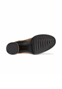 Semelle en suède marron avec un fond en caoutchouc noir, présentant des rainures texturées pour l'adhérence et un design de bord lisse.