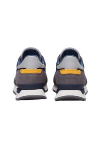 Scarpe sportive con tomaia in suede grigio e rete, dettagli blu e un'etichetta gialla. Suola intermedia spessa in bianco con suola esterna nera testurizzata.