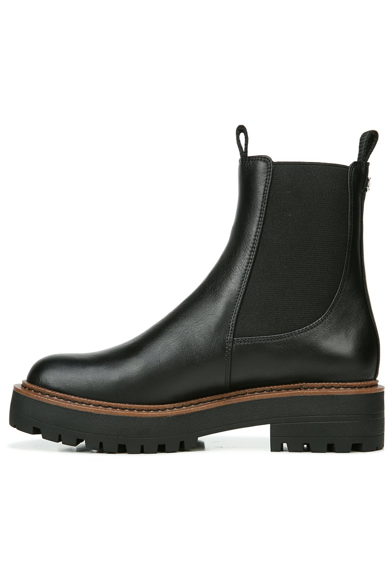 Stivale alla caviglia in pelle nera con pannelli laterali elastici, finitura testurizzata, suola in gomma spessa e linguette per facilitare l'indosso.