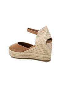 Espadrille de cuña de gamuza marrón con parte trasera de tela beige texturizada, punta redonda, correa en el tobillo y plantilla intermedia de yute trenzado.