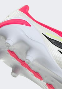 Scarpetta da calcio bianca e rosa con tomaia testurizzata, dettagli neri e numerose tacchette bianche su suola bianca. Presenta dettagli "POWERSPINE" e "STRIKEFRAME".