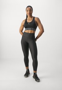 Puma KEEPS BRA - Športni modrček s srednjo podporo - black