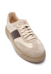 Beige suède en leren sneakers met een bruine streep, getextureerde zijkanten, ronde neus en beige veters. Rubberzool met een getextureerde grip.