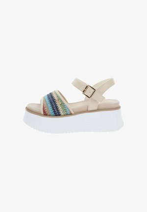 Sandalia de plataforma beige con suela blanca gruesa, tira frontal tejida multicolor y tira ajustable en el tobillo con hebilla dorada.