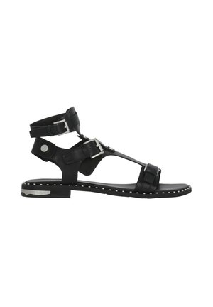 Sandalo piatto nero con tre fibbie argentate regolabili, cinturino alla caviglia e piccoli borchietti argentati lungo il bordo della suola e il tacco.
