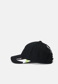 Zwarte baseballpet met een gebogen rand, voorzien van een wit en groen ontwerp aan de zijkant, en logo-accenten op de voorkant en achterkant.
