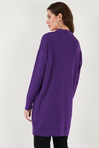 Lila stickad tröja med ribbad textur, långa ärmar och avslappnad passform. Har en rund halsringning och når till mitten av låret.