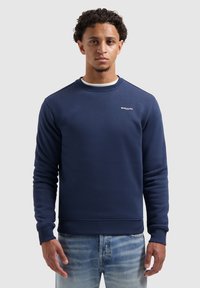 Navy katoenen sweatshirt met een ronde hals, ribbelmanchetten en een ribbelzoom. Beschikt over een klein wit logo op de borst en een gladde textuur.