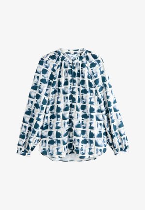 Witte blouse met een blauw abstract rasterpatroon, lange mouwen, geplooide halslijn en een relaxte pasvorm. Zachte stof met een subtiele textuur.