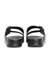 Black sandals with two upper straps featuring buckles. The textured sole is slightly elevated, providing a minimalist design with a smooth finish.