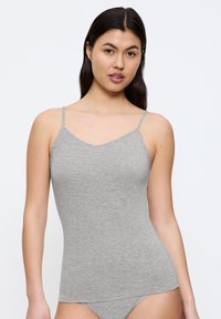 Camisola grigia aderente con spalline sottili, realizzata in tessuto leggero e testurizzato, con scollatura a barca e bordi senza cuciture.