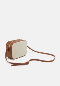 Borsa a tracolla di forma rettangolare. Parte frontale in tessuto beige e lati in pelle marrone, con una cerniera dorata e una tracolla regolabile.
