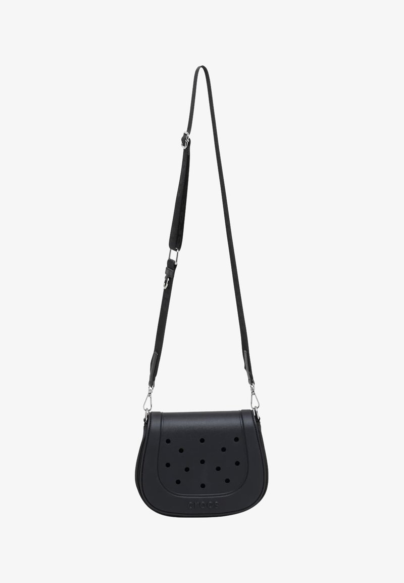 Petit sac bandoulière noir avec sangle réglable et trous circulaires perforés sur le rabat avant, fabriqué en matériau lisse.