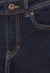 Granatowe dżinsy z denimu w zbliżeniu, ukazujące guzik z marką "Pull&Bear", szlufkę na pasek oraz kontrastujące pomarańczowe przeszycia wokół kieszeni i szwów.