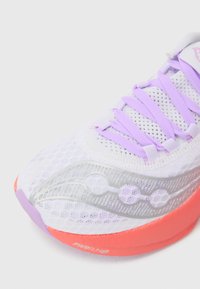 Zapatilla de running blanca de malla con cordones lilas, acentos plateados y suela en color naranja-rosado. Presenta un diseño perforado y una superficie texturizada.