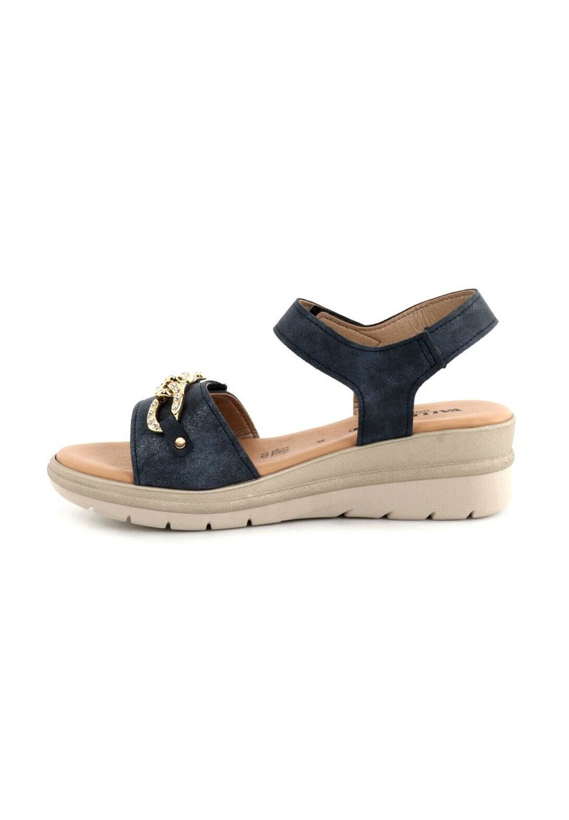 Sandalo con zeppa in suede blu con cinturino alla caviglia regolabile, caratterizzato da un accento metallico sulla parte superiore e suola testurizzata per una migliore aderenza.