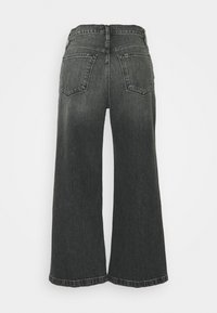 Höga vida svarta jeans med en blekt design. Har två bakfickor och råa kanter. Tillverkade av denim med en strukturerad yta.