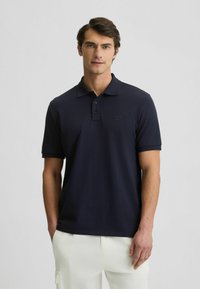 Polo shirt blu navy in misto cotone con maniche corte, colletto e patta con tre bottoni; presenta un logo sottile sul petto.