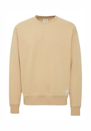 Beige huppari, joka on valmistettu pehmeästä kankaasta. Siinä on pyöreä kaula-aukko, ribbed hihansuut ja helma. Alareunassa on pieni brändilogo.