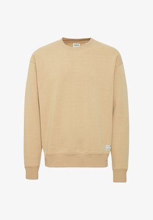 Sweatshirt beige en tissu doux avec un col rond, des poignets et un ourlet côtelés. Présente une petite étiquette de marque sur le côté inférieur.