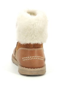 Bottine en cuir marron avec un doux revers en fausse fourrure blanche, des accents cousus et une semelle extérieure texturée. Présente un design à bout arrondi.