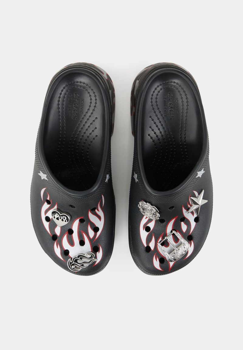 Zuecos negros con diseños de llamas rojas y accesorios metálicos, con orificios de ventilación y una suela texturizada para mayor agarre y comodidad.