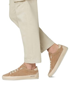 Beige Wildleder-Sneaker mit niedrigem Profil, flacher Gummisohle und einem glatten Leder-Akzent. Enthält perforierte Details und eine Schnürung.