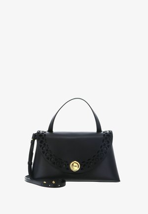 Sac à main en cuir noir avec une poignée supérieure, un motif décoratif découpé sur le rabat, une fermeture circulaire dorée et une bandoulière réglable.