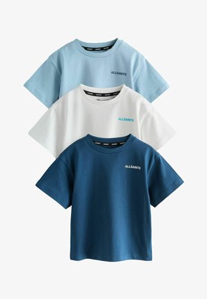 Trois T-shirts en coton de couleurs bleu clair, blanc et bleu foncé. Chacun possède un col rond et des manches courtes avec le logo de la marque sur la poitrine.