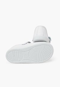 Weiße Sneakers mit einem Obermaterial aus glattem Leder, grauen Akzenten, einer flachen Gummisohle und einem sicheren Absatz mit Zugangszipper. Sie verfügen über ein schlichtes Design.