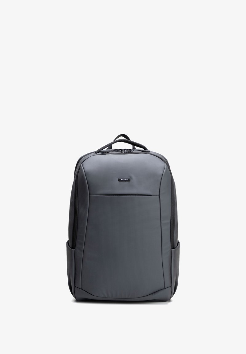 Donkergrijze rechthoekige rugzak met ritsvak aan de voorkant, zijvakken, bovenhandvat en merklabel gecentreerd vlak bij de bovenkant.