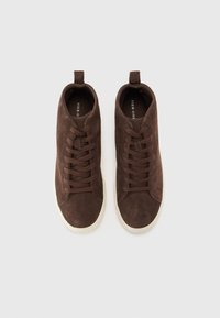 Brown suede high-top sneakers with lace-up closure and pull tab, featuring a contrasting white rubber sole and smooth texture.