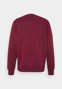 Mörkröd långärmad crewneck sweatshirt med ribbad mudd vid ärmar och midja, visad från baksidan mot en vit bakgrund.