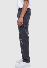 Karl Kani OG GY WOREAR LOGO PRINT DENIM - Traperice ravnih nogavica - bleached black