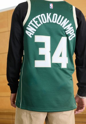 Widok z tyłu osoby noszącej zieloną koszulkę NBA z nazwiskiem "ANTETOKOUNMPO" i numerem 34, pod spodem czarne długie rękawy.