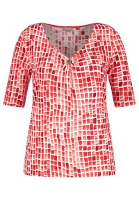Naisten punavalkoinen ruutukuosinen paita, jossa on kyynärpäidhihnat ja pieni koriste kerättyjen V-kaulanaukossa.